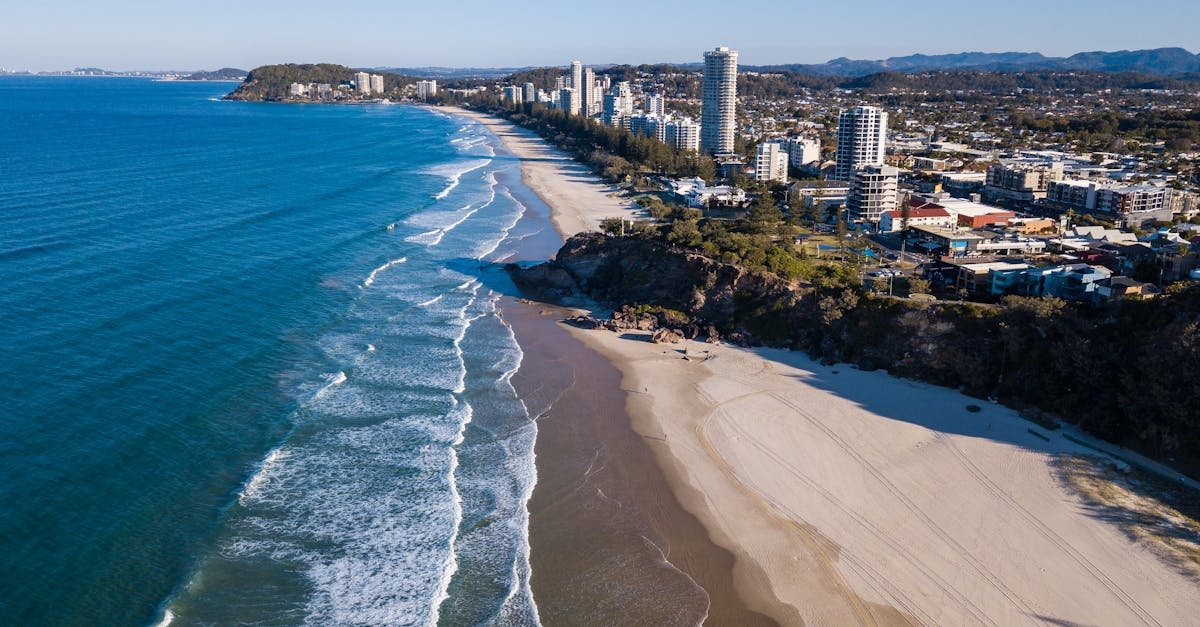 Stunning aerial view of coastline with beaches, city skyline, and scenic ocean.