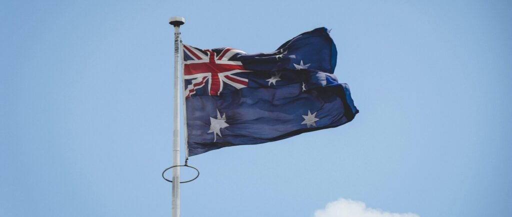 Australian national flag waving on a flagpole against a clear blue sky in Perth.