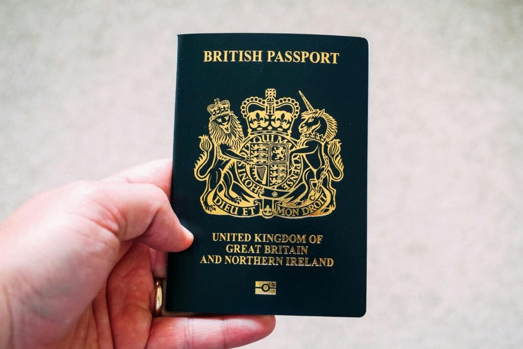 Close-up of a hand holding a British passport, symbolizing citizenship and travel.